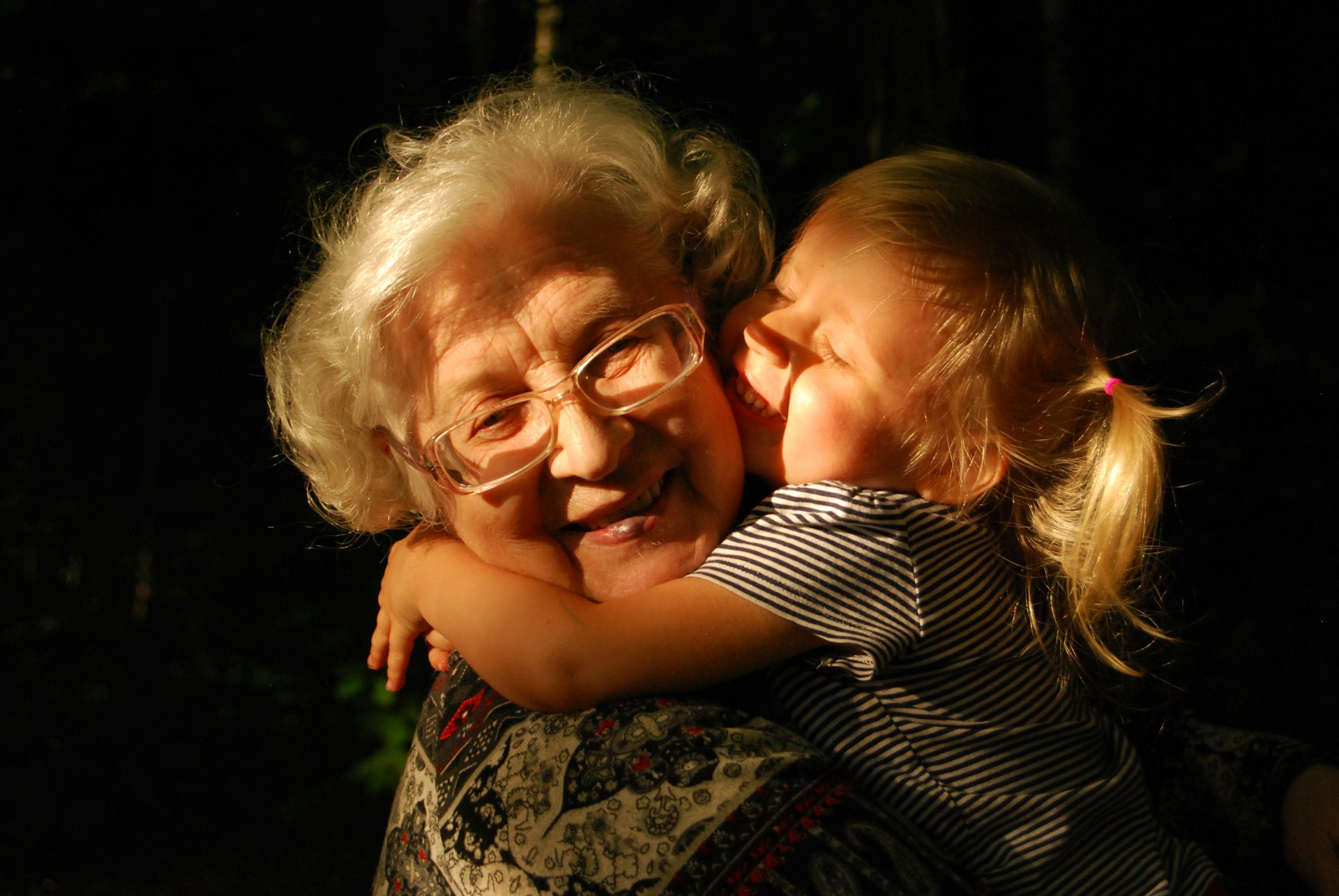 a grandmother with her granddaughter hugging and kissing